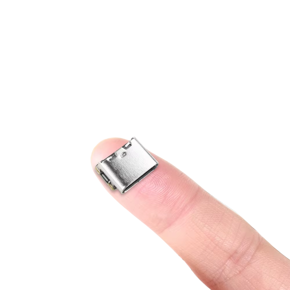 Small USB-C charging connector module placed on a fingertip to show its compact size.